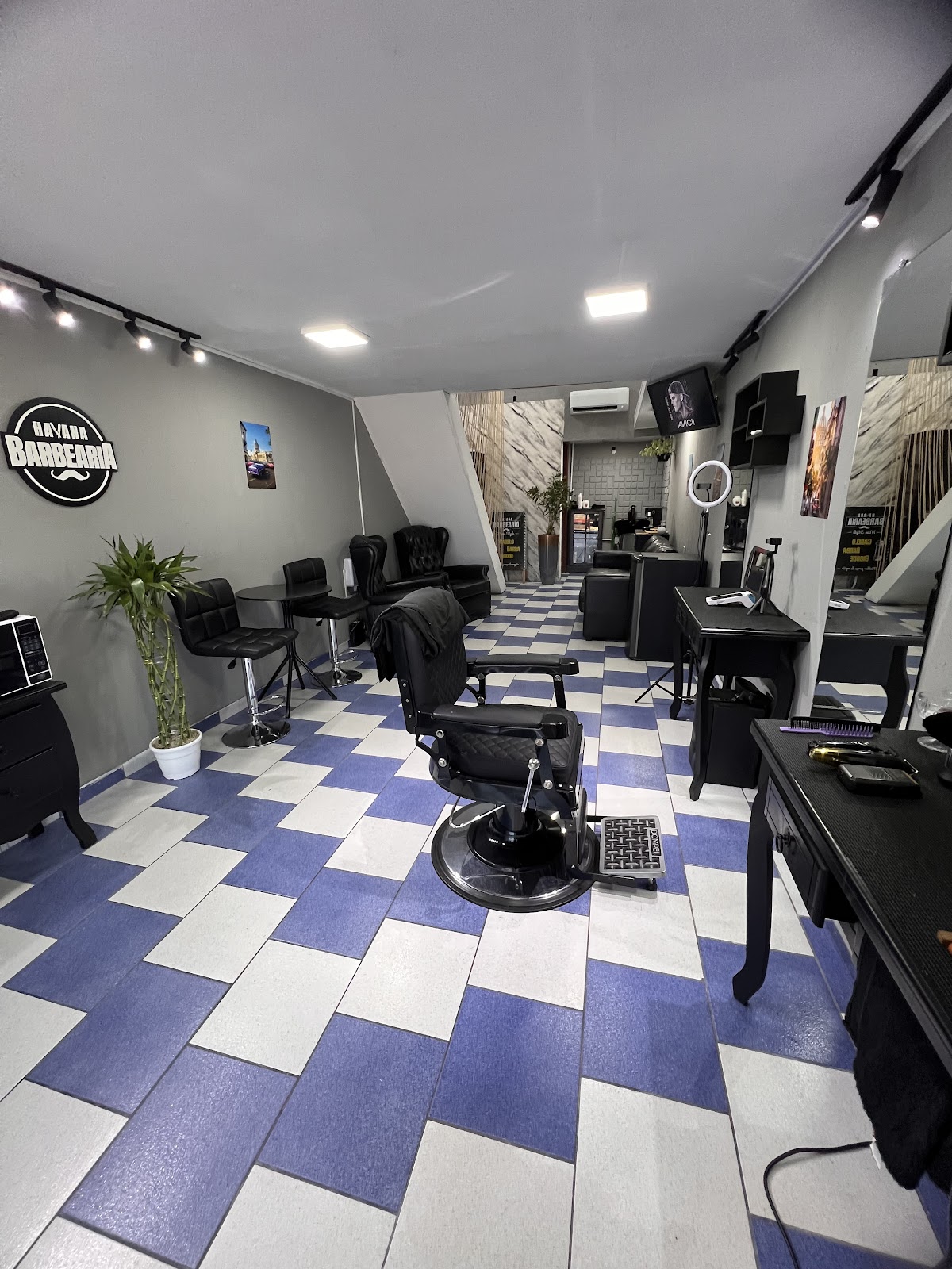 Interior da Havana Barbearia com piso xadrez azul e branco, no Xaxim, Curitiba