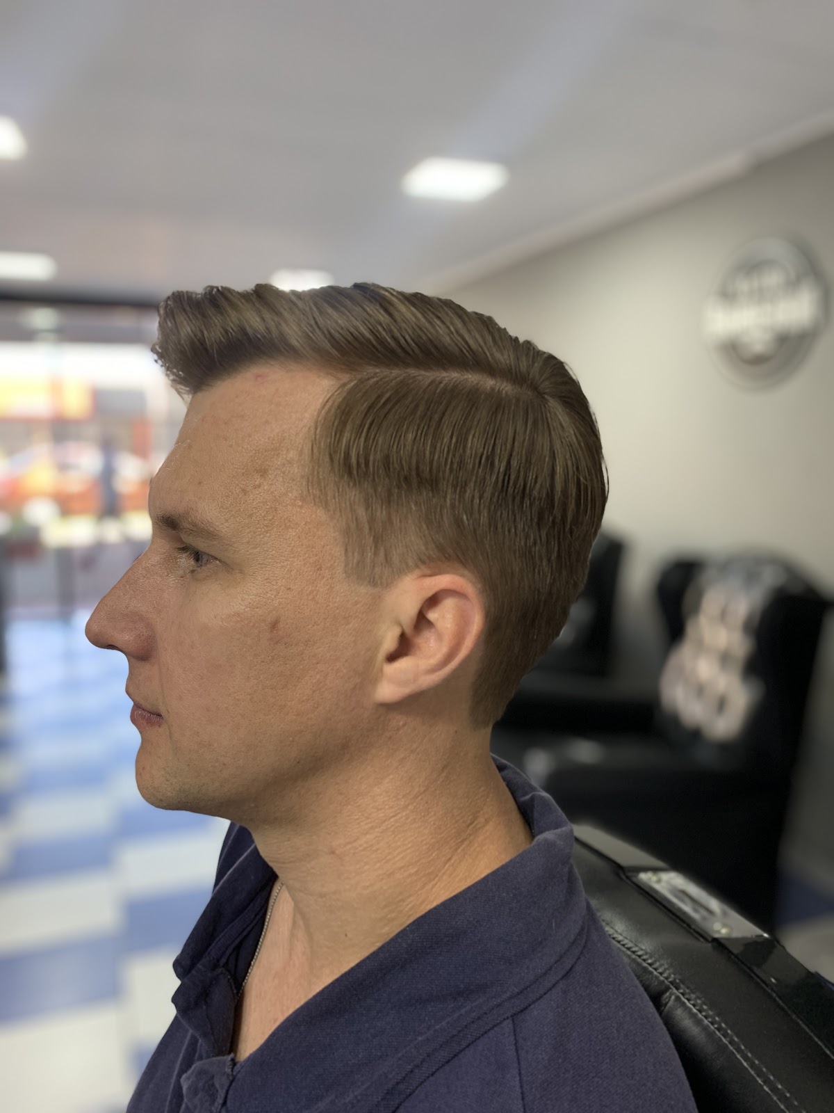Corte finalizado de cliente, com o piso xadrez azul e branco ao fundo