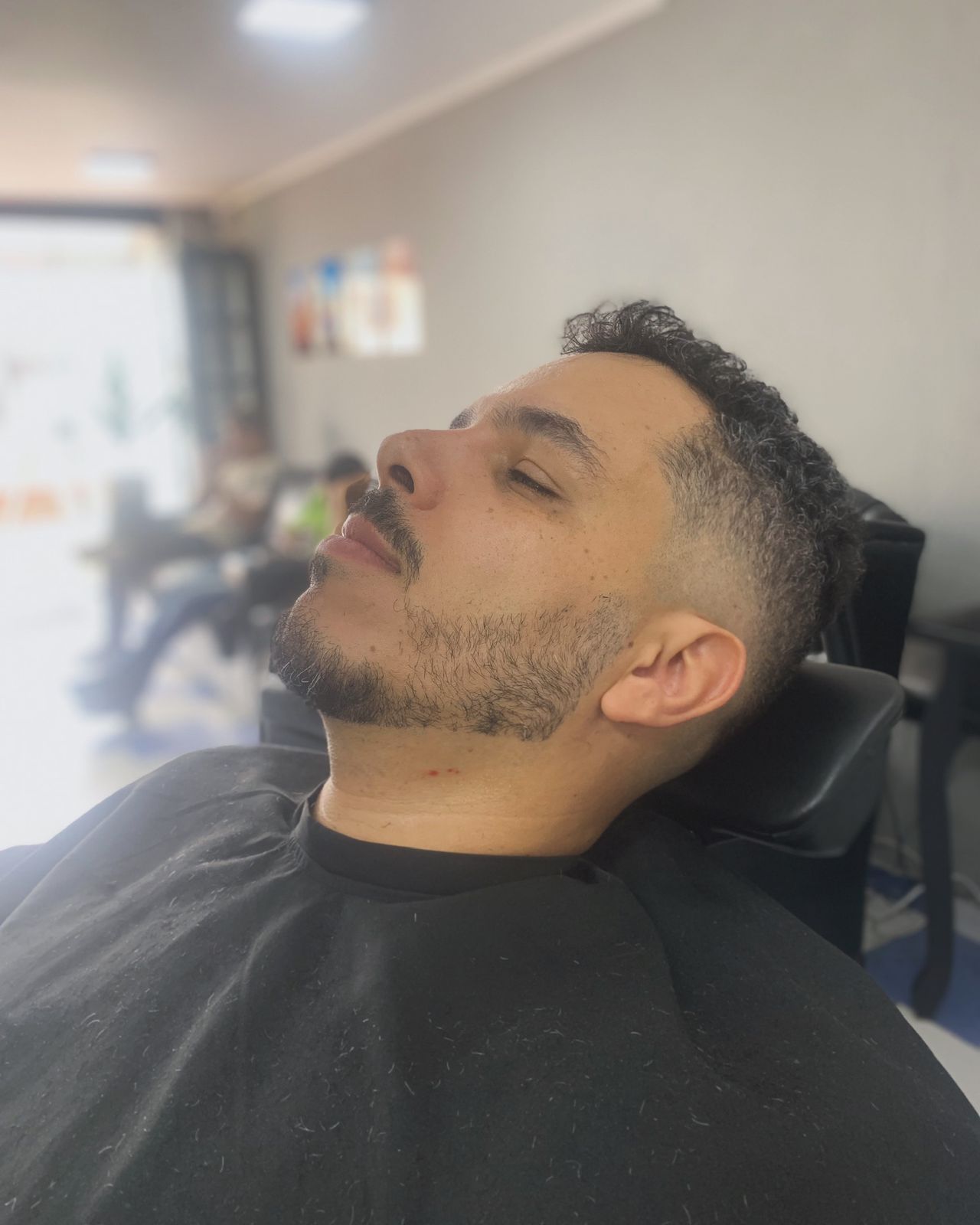 Cliente sendo atendido na cadeira da Havana Barbearia